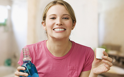 A woman holding a bottle of mouthwash