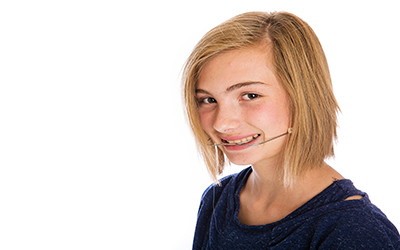 A young girl wearing orthodontic headgear