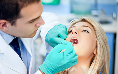 A dentist working on a female patient teeth