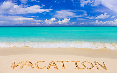 An image of the ocean with the words vacation written in the sand on the beach