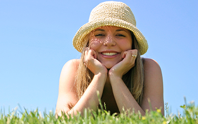 A woman laying down in grass smiling
