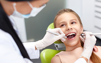 Dentist examining a girls teeth
