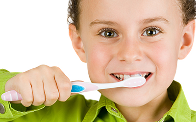 A young child brushing his teeth